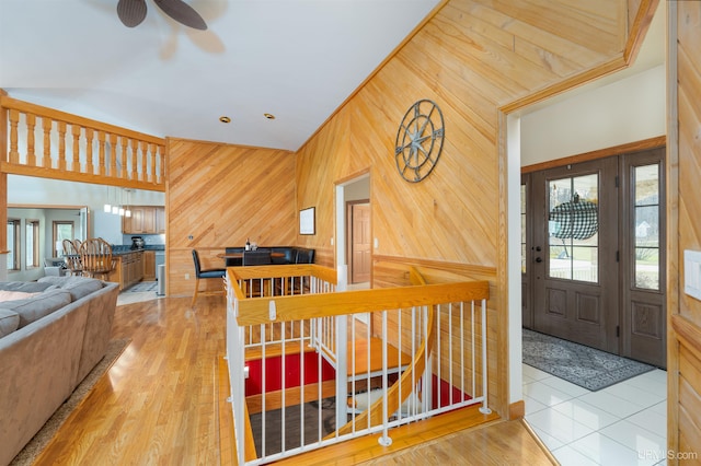 foyer entrance featuring wooden walls, light hardwood / wood-style flooring, and ceiling fan