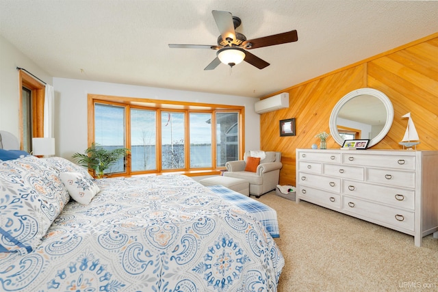 bedroom featuring a textured ceiling, light colored carpet, ceiling fan, wooden walls, and an AC wall unit