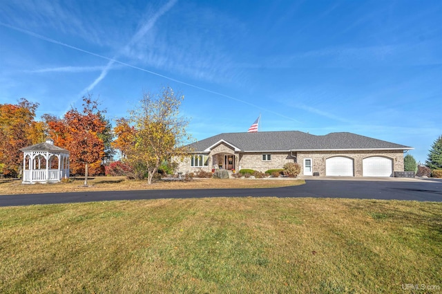 ranch-style house featuring a gazebo, a garage, and a front lawn