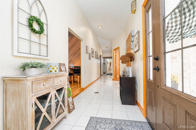 entryway featuring light tile patterned flooring and vaulted ceiling