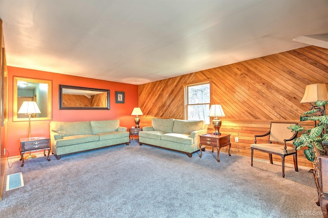 carpeted living room with vaulted ceiling and wooden walls