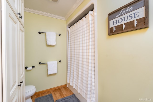 bathroom featuring hardwood / wood-style flooring, toilet, ornamental molding, and walk in shower