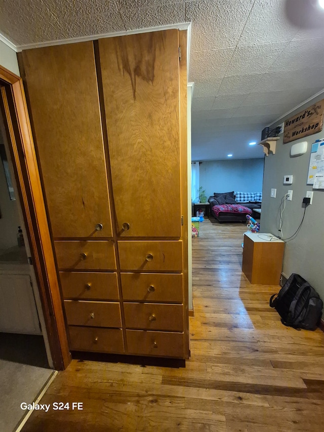 hall featuring crown molding and light hardwood / wood-style flooring