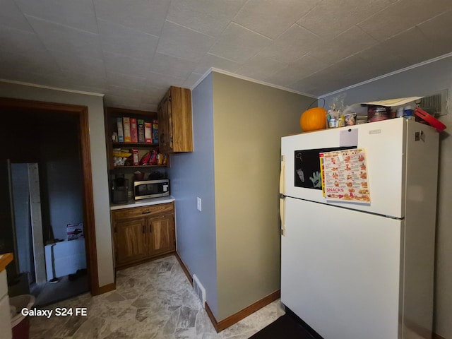 kitchen featuring white refrigerator and ornamental molding