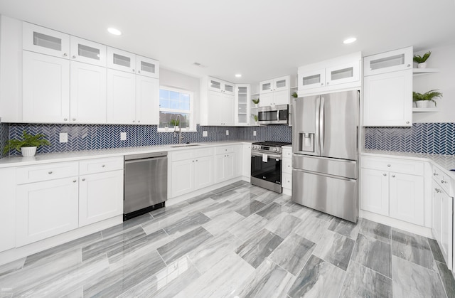 kitchen featuring white cabinets, appliances with stainless steel finishes, and tasteful backsplash