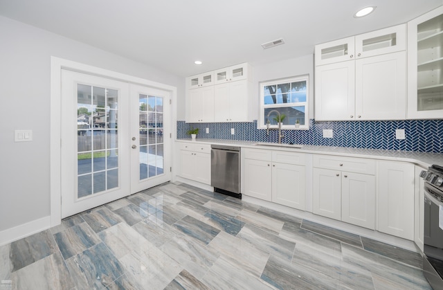 kitchen featuring french doors, backsplash, stainless steel appliances, sink, and white cabinets