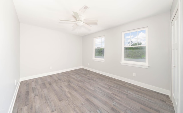 empty room with dark hardwood / wood-style flooring and ceiling fan