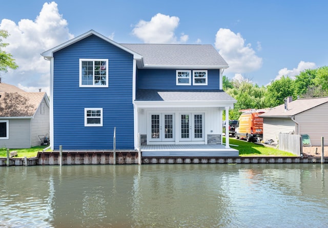 rear view of house with a water view and french doors