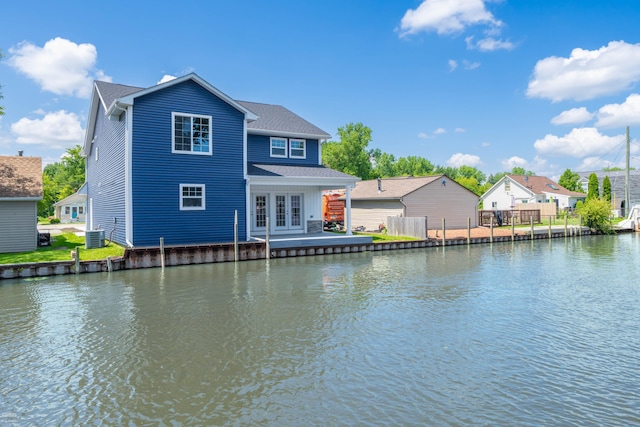 back of property with a water view and central air condition unit