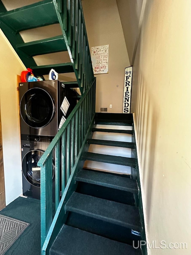 stairway featuring carpet and stacked washer and dryer