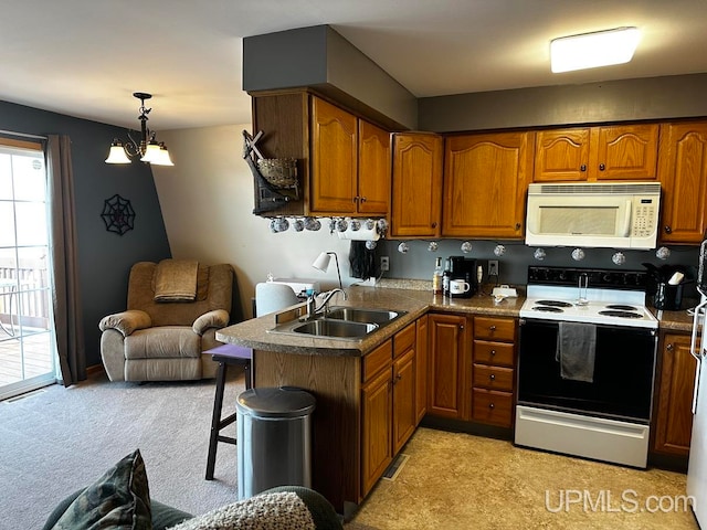 kitchen featuring sink, decorative light fixtures, electric range, a kitchen breakfast bar, and kitchen peninsula