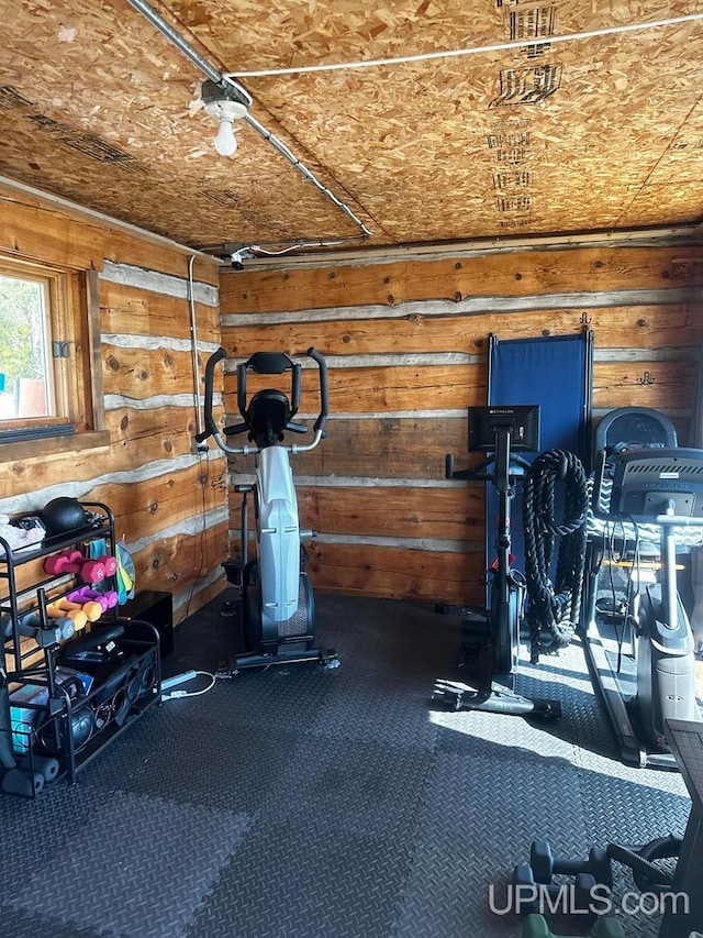 workout area featuring carpet and wood walls