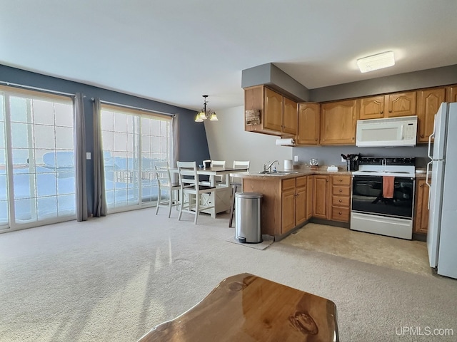 kitchen featuring sink, hanging light fixtures, light colored carpet, kitchen peninsula, and white appliances