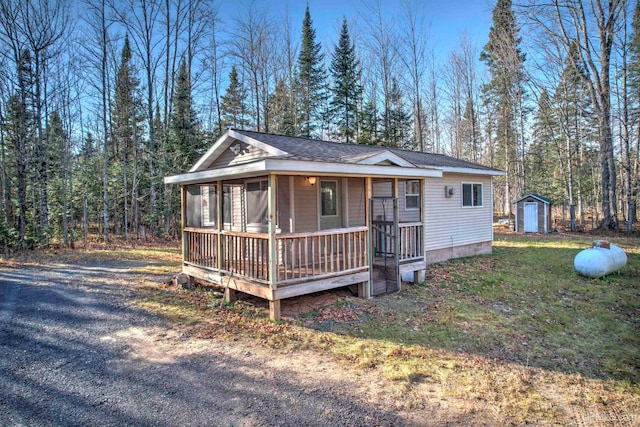 view of front of property featuring a shed and a front lawn