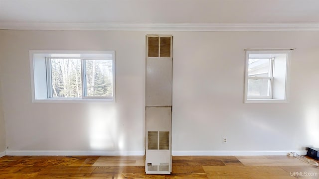 spare room with hardwood / wood-style flooring and crown molding