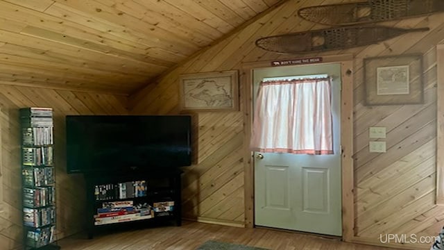 living room with lofted ceiling, wood-type flooring, wooden walls, and wooden ceiling