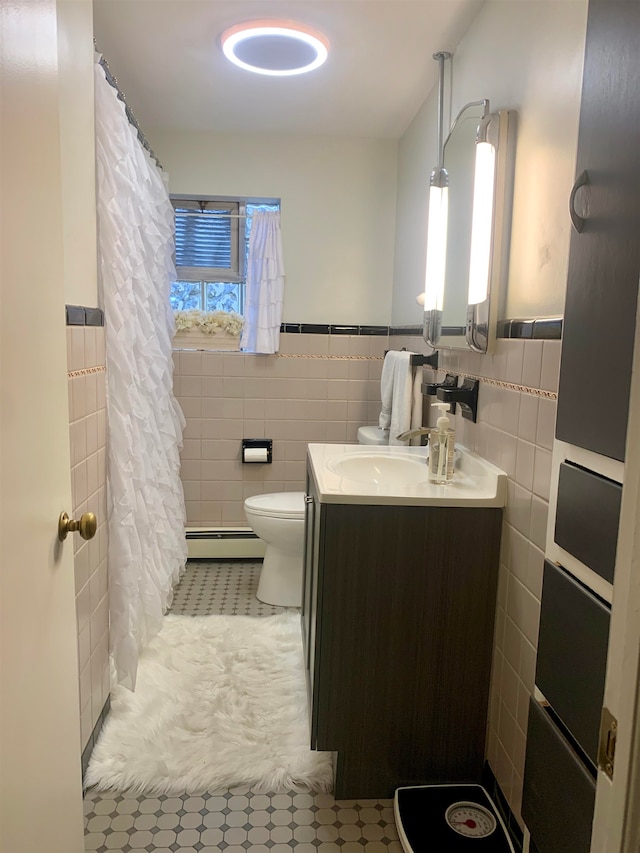 bathroom featuring vanity, a baseboard radiator, tile walls, tile patterned flooring, and toilet