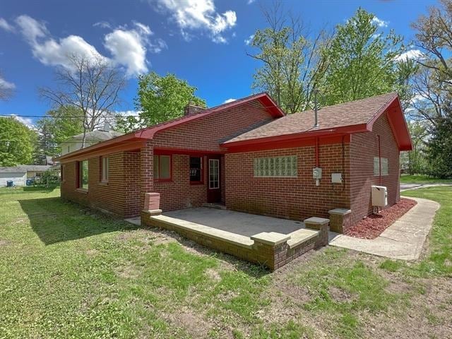 rear view of property with a yard and a patio area