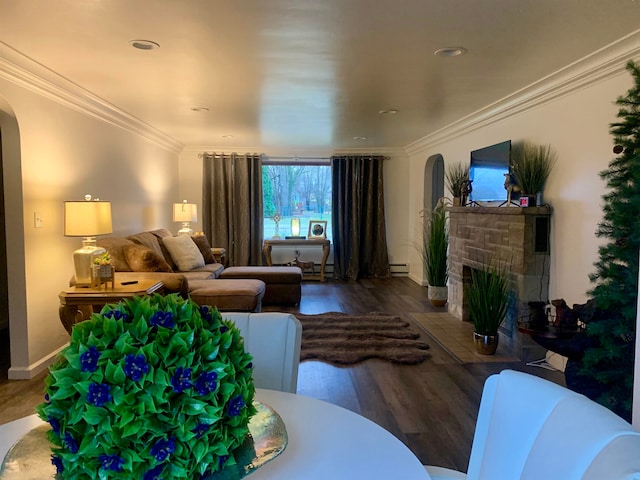 living room featuring baseboard heating, a fireplace, hardwood / wood-style floors, and ornamental molding