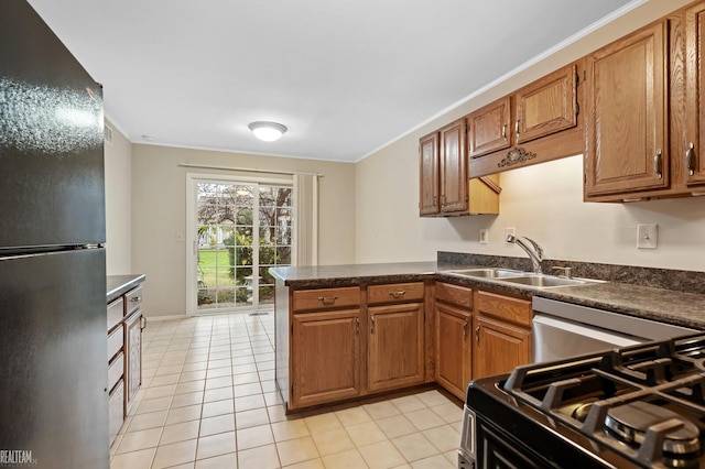 kitchen with black refrigerator, kitchen peninsula, sink, stainless steel range oven, and light tile patterned flooring