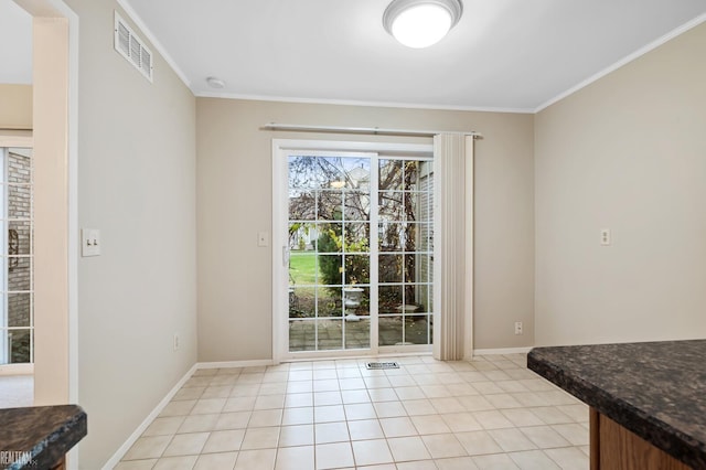 doorway featuring ornamental molding and light tile patterned floors