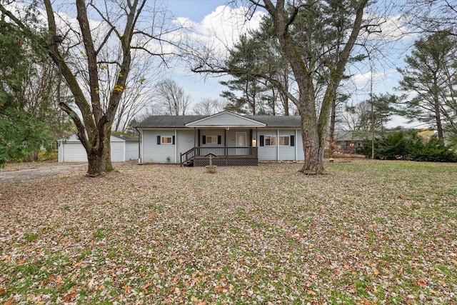 ranch-style home featuring a porch, a garage, and an outdoor structure