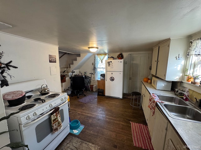 kitchen with white appliances, sink, and dark wood-type flooring