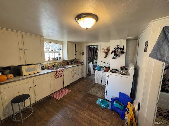 kitchen featuring cream cabinets, white appliances, dark hardwood / wood-style floors, and sink