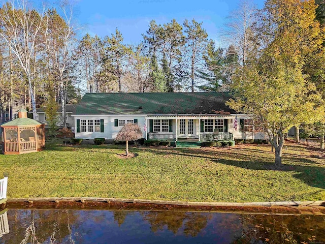 view of front of home with a gazebo, a water view, and a front yard