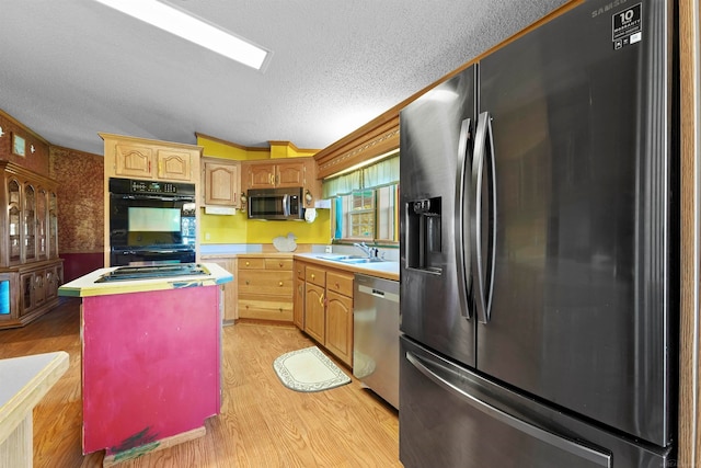 kitchen with lofted ceiling, black appliances, sink, light hardwood / wood-style flooring, and a kitchen island