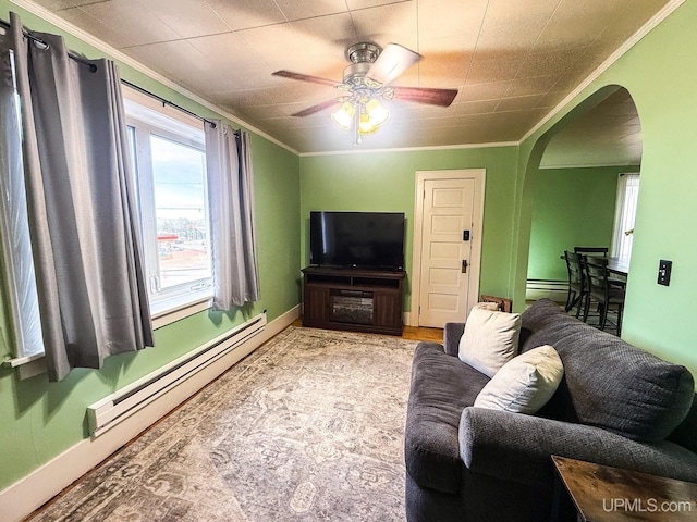 657 Lake Ave, Ironwood, MI 49938 - living room featuring arched walkways, ornamental molding, a baseboard heating unit, ceiling fan, and baseboards