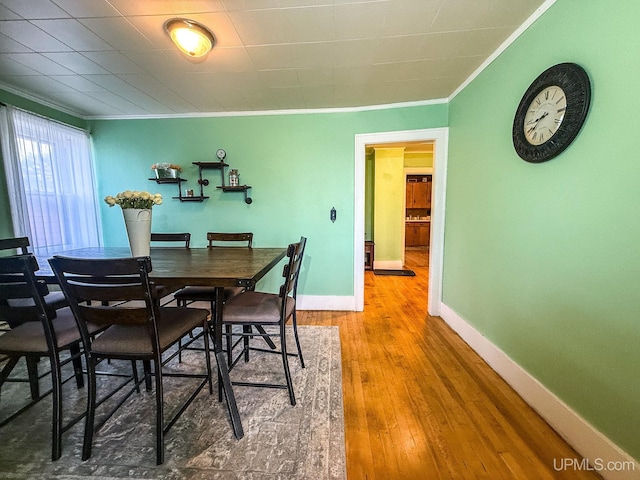 dining space featuring hardwood / wood-style floors and ornamental molding