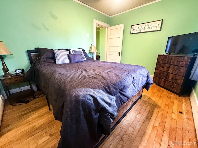 bedroom featuring light hardwood / wood-style flooring and ornamental molding