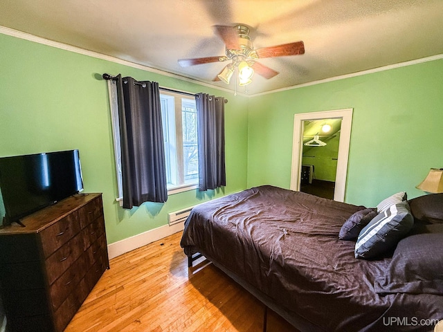 bedroom with light wood-type flooring, ceiling fan, and ornamental molding