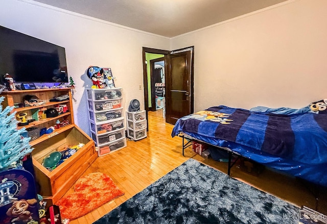 bedroom with crown molding and hardwood / wood-style floors