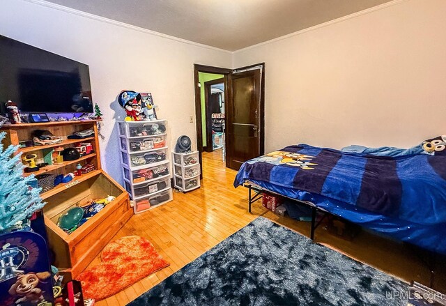657 Lake Ave, Ironwood, MI 49938 - bedroom with ornamental molding and hardwood / wood-style flooring