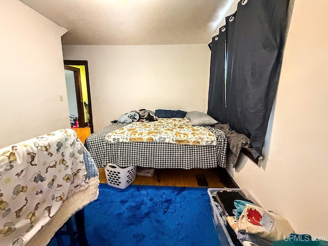 bedroom featuring hardwood / wood-style flooring and a textured ceiling