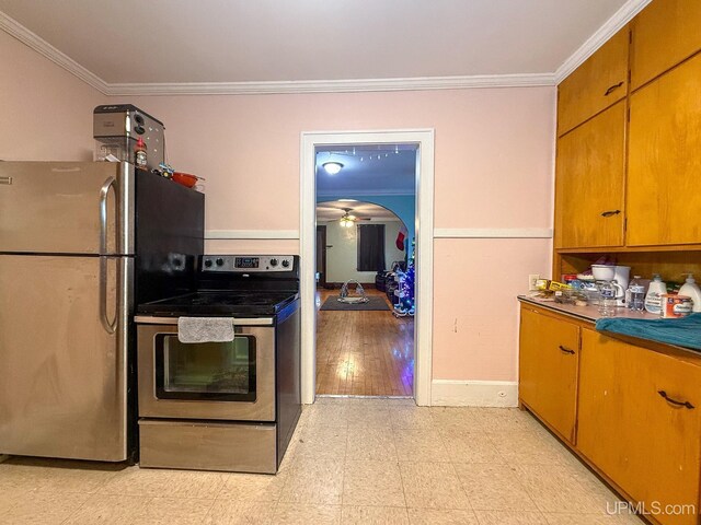 657 Lake Ave, Ironwood, MI 49938 - kitchen with stainless steel appliances, crown molding, ceiling fan, brown cabinets, and light flooring