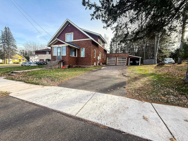 view of front facade featuring a garage, an outdoor structure, and a front yard