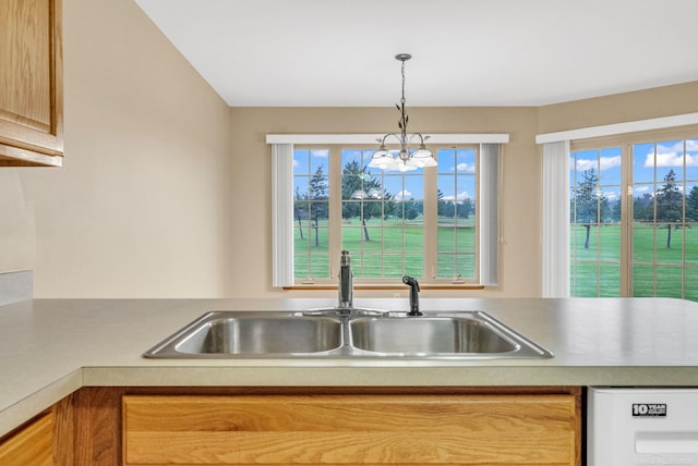 kitchen featuring a chandelier, light brown cabinets, hanging light fixtures, and sink