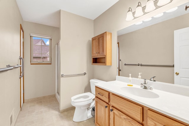 bathroom with vanity, toilet, and a shower with shower door