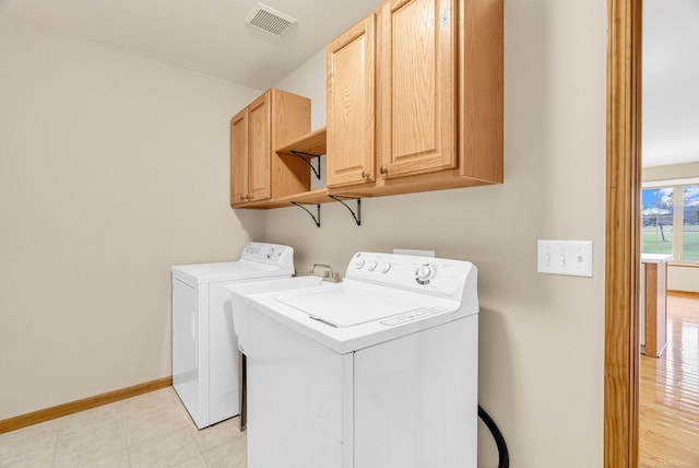 laundry room with cabinets, separate washer and dryer, and light hardwood / wood-style floors