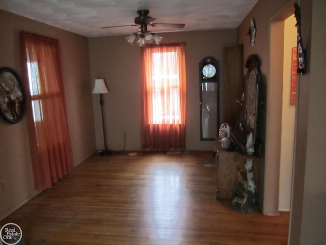 unfurnished living room with ceiling fan, wood-type flooring, and a textured ceiling