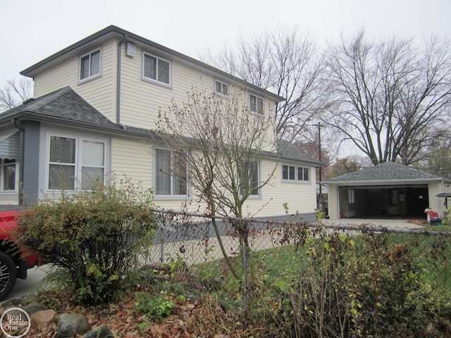 back of property featuring an outbuilding and a garage