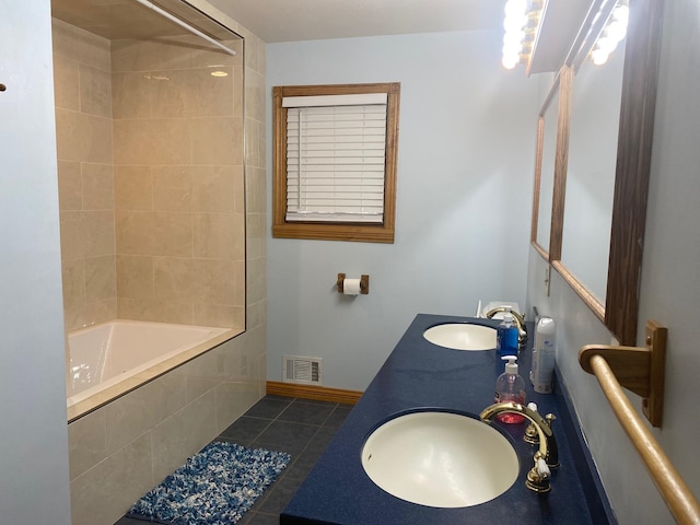 bathroom with tile patterned flooring, vanity, and tiled shower / bath