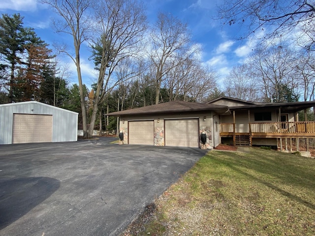 2250 Dryer Rd, Standish, MI 48658 - view of front of property featuring an attached garage, asphalt driveway, a front lawn, and an outbuilding