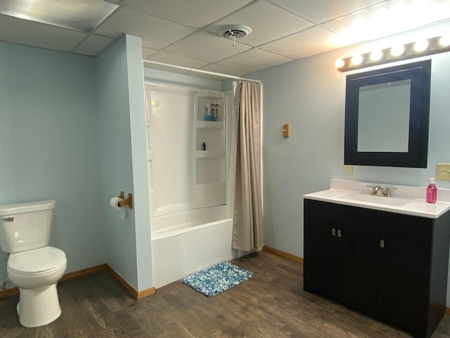 full bathroom with shower / bath combo, a paneled ceiling, vanity, hardwood / wood-style floors, and toilet