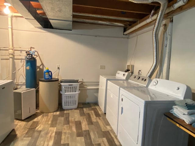 washroom featuring hardwood / wood-style floors and washing machine and clothes dryer