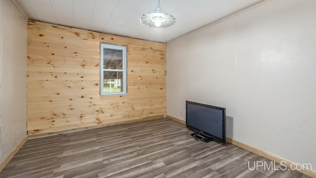 unfurnished room featuring hardwood / wood-style floors and wooden walls