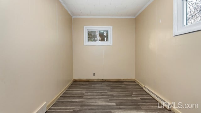 unfurnished room featuring ornamental molding, dark wood-type flooring, and baseboard heating